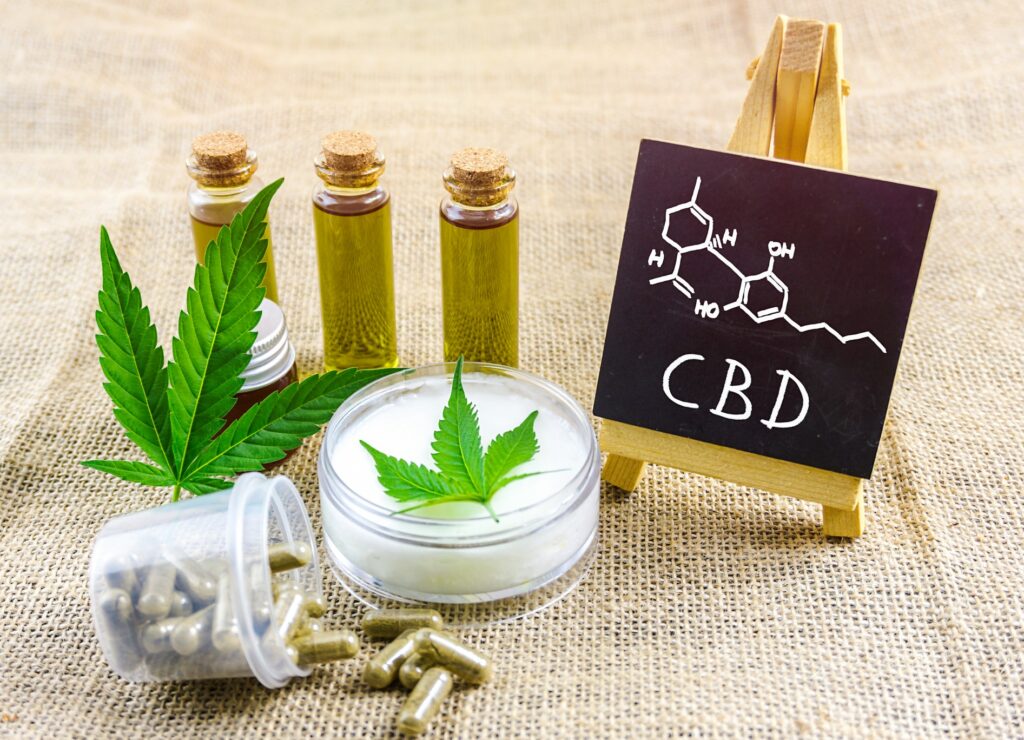 Cbd oils and topical cream and blackboard with chemical structure
