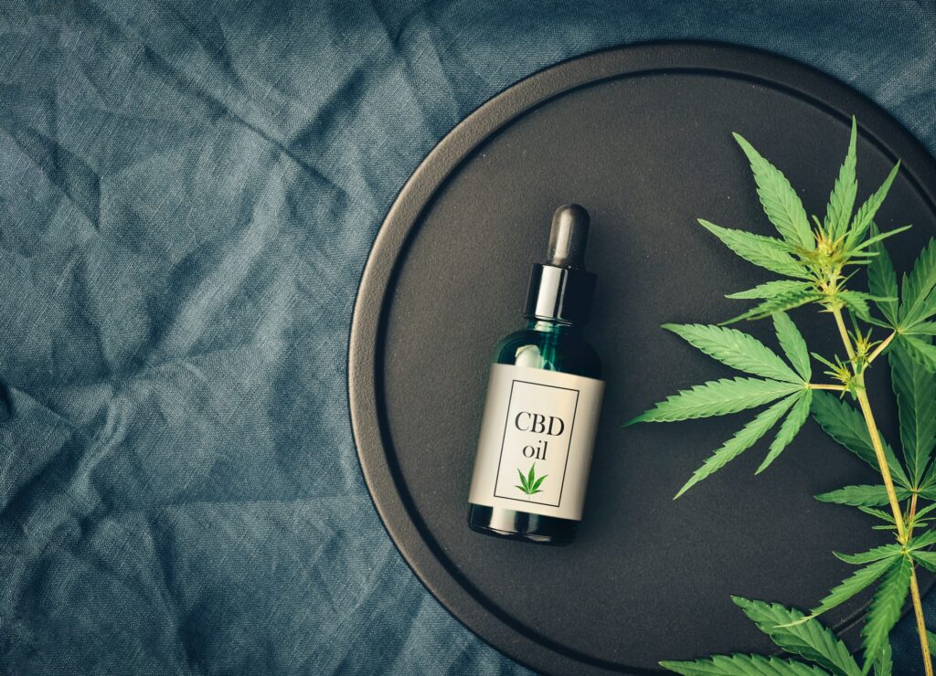 Medical marijuana cannabis products CBD oil and hemp leaves on dark background