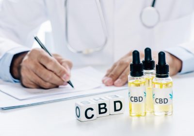 selective focus of cubes and cannabis oil with lettering CBD