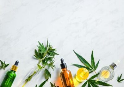 Various glass bottles with CBD oil, THC tincture hemp leaves on marble background Cosmetics CBD oil